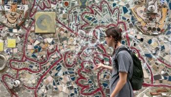 费城，一名学生站在一幅马赛克画前.